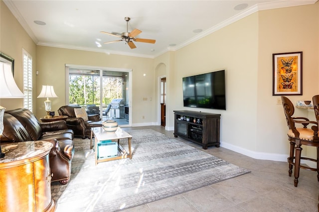 tiled living room featuring ceiling fan, baseboards, arched walkways, and ornamental molding