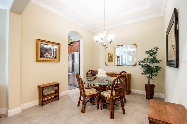 dining space featuring crown molding, baseboards, arched walkways, and a chandelier