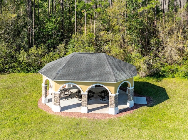 surrounding community with a gazebo, a lawn, a wooded view, and a patio