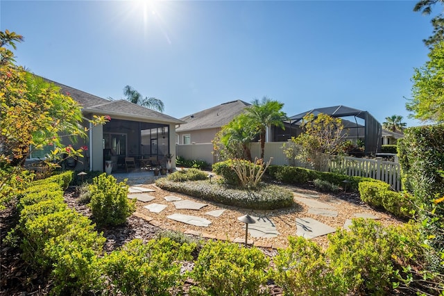 back of house featuring a patio area, a fenced backyard, and a sunroom