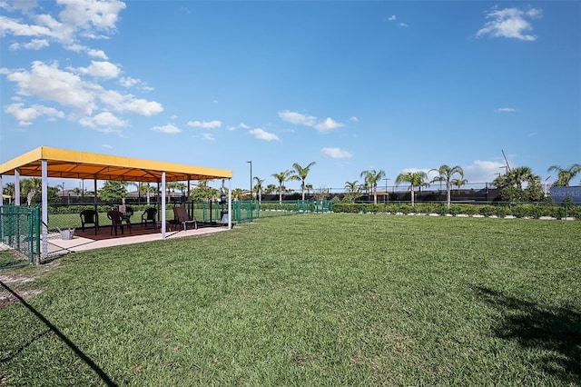 view of property's community featuring a yard and fence