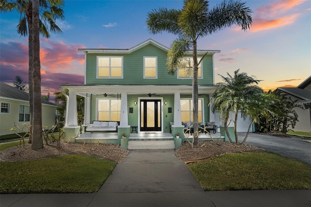 view of front of house with a garage, covered porch, and driveway