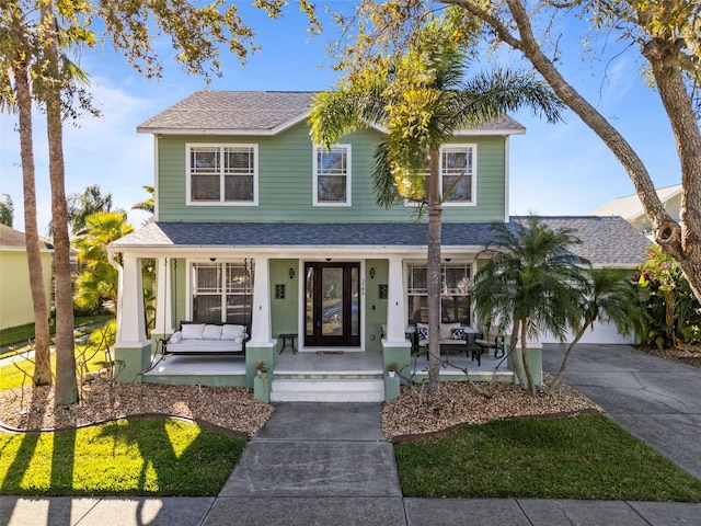 view of front of house featuring a porch, driveway, and a shingled roof