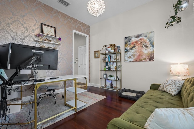 office area featuring wood finished floors, visible vents, baseboards, wallpapered walls, and a notable chandelier