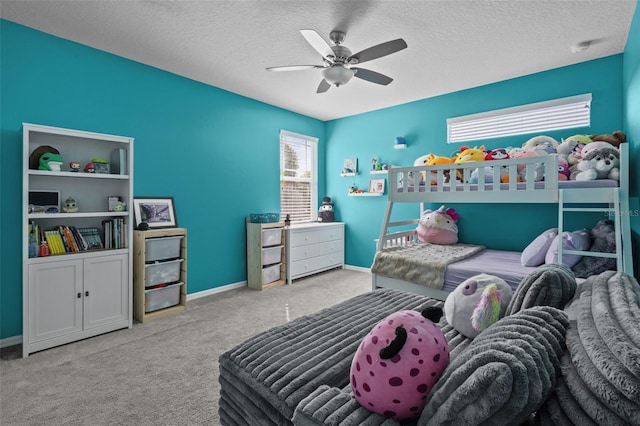 carpeted bedroom featuring ceiling fan, baseboards, and a textured ceiling