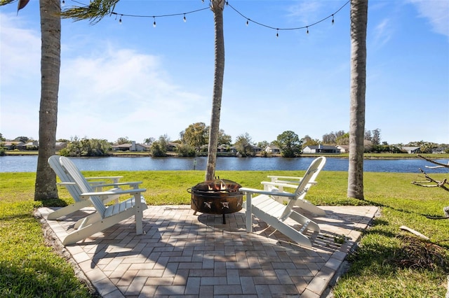 view of patio with a fire pit and a water view