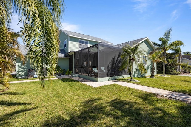 rear view of house featuring glass enclosure and a yard