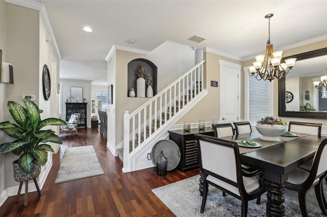 dining space with visible vents, crown molding, a chandelier, stairs, and wood finished floors