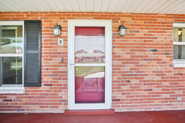 doorway to property with brick siding