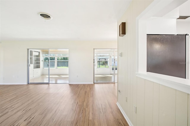 interior space featuring light wood-style floors, visible vents, and baseboards