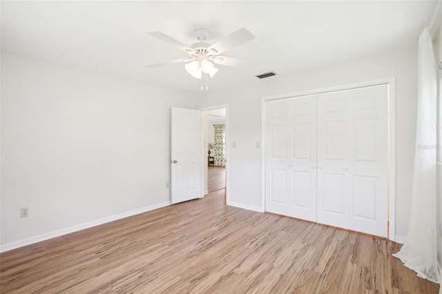 unfurnished bedroom with visible vents, a ceiling fan, a closet, light wood finished floors, and baseboards