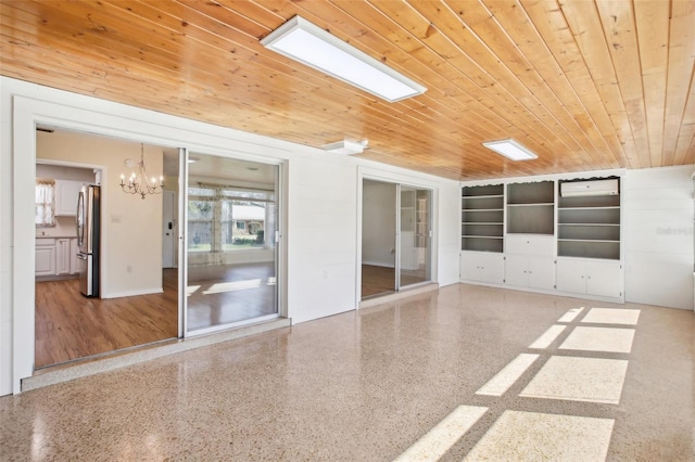 unfurnished room featuring speckled floor, an inviting chandelier, and wooden ceiling