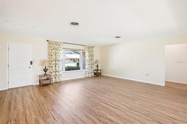 interior space with light wood-type flooring, visible vents, and baseboards