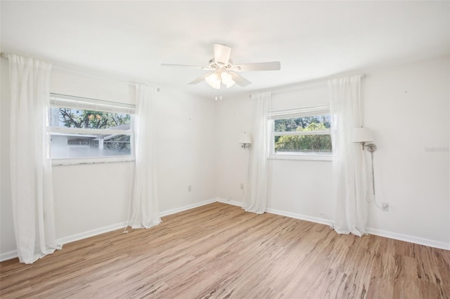 spare room featuring baseboards, light wood-style floors, and ceiling fan