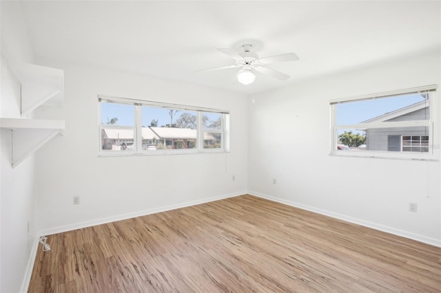 spare room with baseboards, wood finished floors, and a ceiling fan