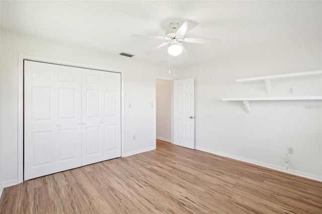 unfurnished bedroom featuring light wood-type flooring, visible vents, a ceiling fan, a closet, and baseboards