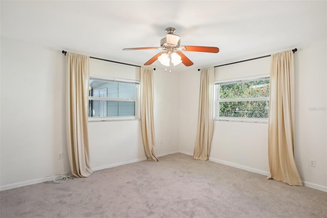 unfurnished room with light colored carpet, baseboards, and ceiling fan