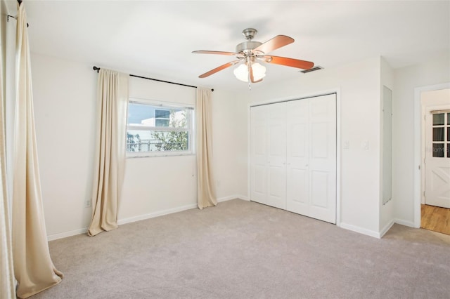 unfurnished bedroom featuring visible vents, baseboards, light colored carpet, and a closet