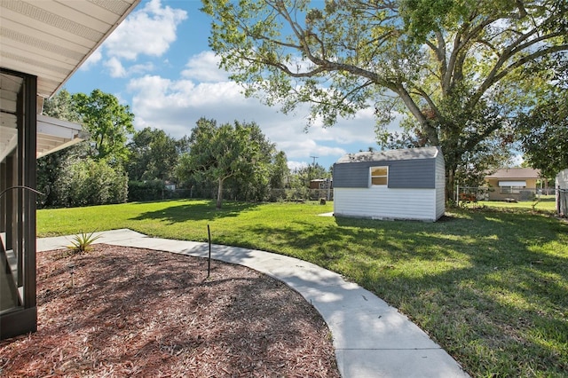 view of yard featuring a storage unit, an outbuilding, and a fenced backyard