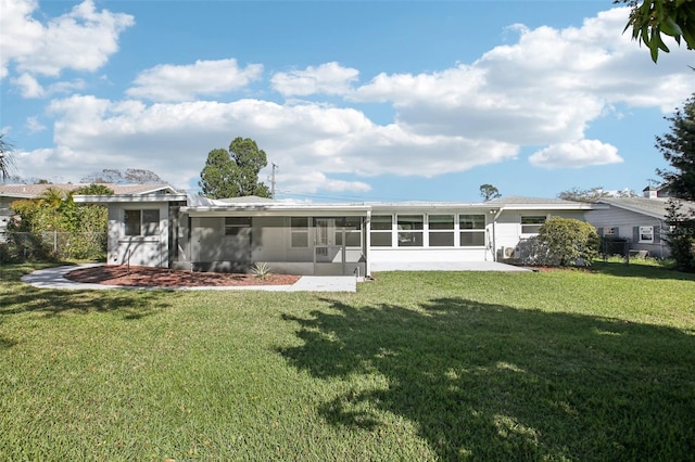 rear view of house with a yard, fence, and a sunroom