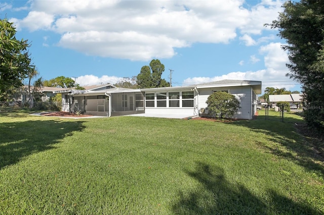 rear view of house with a gate, fence, a lawn, and a sunroom