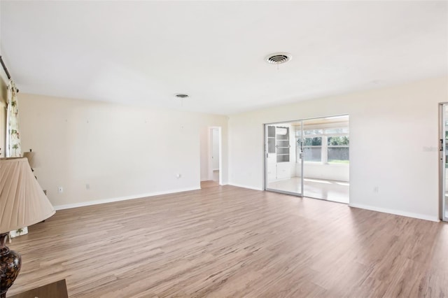 1841 5th St SE, Winter Haven, FL 33880 - unfurnished living room featuring baseboards, visible vents, and light wood finished floors