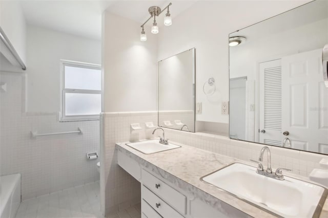 1841 5th St SE, Winter Haven, FL 33880 - bathroom featuring a sink, a wainscoted wall, toilet, and tile walls