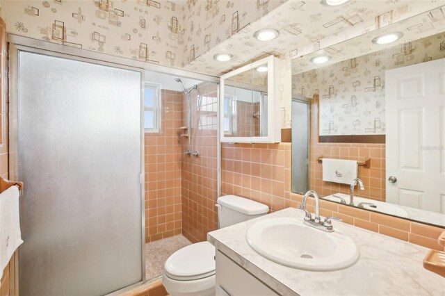 1841 5th St SE, Winter Haven, FL 33880 - bathroom featuring a wainscoted wall, wallpapered walls, a stall shower, tile walls, and toilet