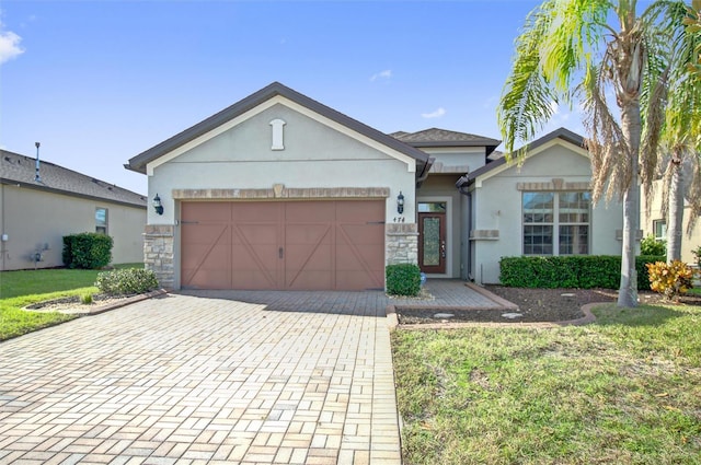 single story home featuring stucco siding, a front lawn, decorative driveway, stone siding, and an attached garage