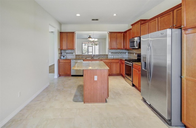 kitchen with visible vents, backsplash, a center island, stainless steel appliances, and a sink