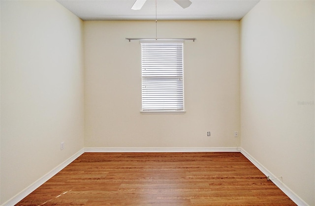 spare room with ceiling fan, light wood-type flooring, and baseboards