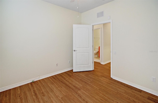 empty room with visible vents, baseboards, a ceiling fan, and light wood finished floors