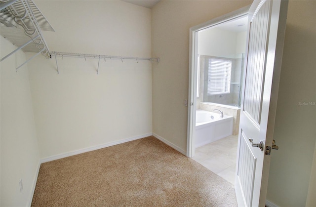 walk in closet with light colored carpet