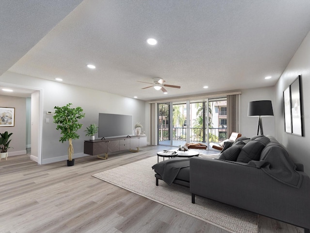 living area with recessed lighting, light wood-type flooring, a textured ceiling, and a ceiling fan