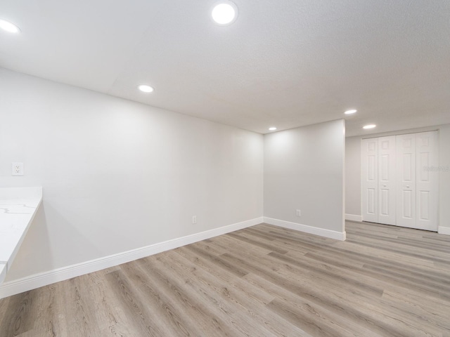 below grade area featuring recessed lighting, baseboards, and light wood-style floors