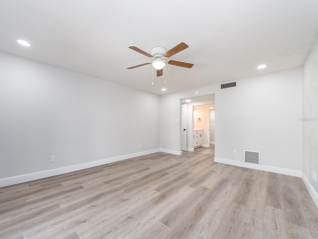 empty room featuring visible vents, baseboards, light wood-type flooring, and a ceiling fan