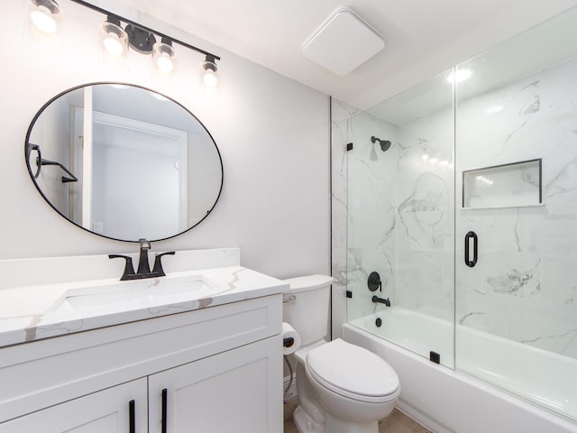 full bath with toilet, vanity, and shower / bath combination with glass door