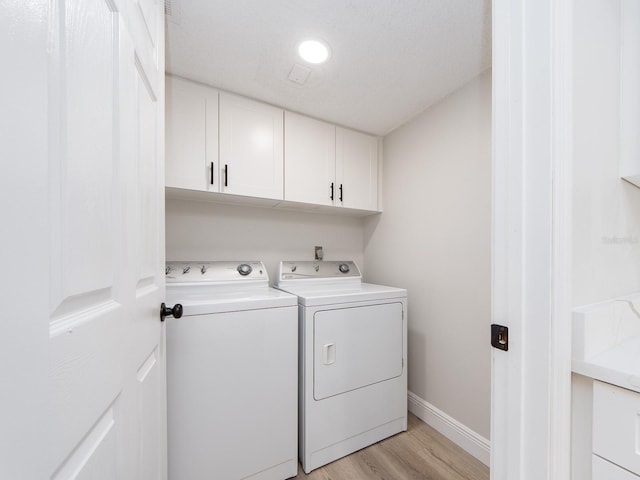 3021 Countryside Blvd Unit 23A, Clearwater, FL 33761 - clothes washing area featuring light wood finished floors, baseboards, cabinet space, and washer and clothes dryer
