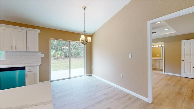 unfurnished dining area with light wood finished floors, recessed lighting, an inviting chandelier, and baseboards