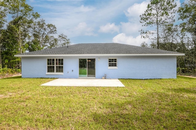 back of property featuring a yard, a patio area, and stucco siding