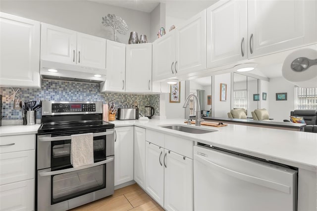 kitchen featuring under cabinet range hood, a sink, light countertops, range with two ovens, and dishwasher