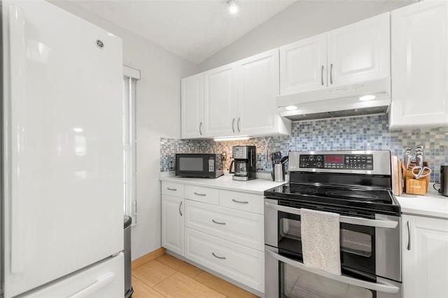 kitchen featuring double oven range, lofted ceiling, freestanding refrigerator, under cabinet range hood, and black microwave