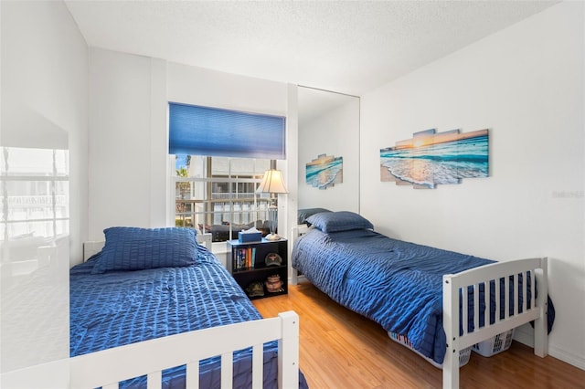 bedroom featuring a textured ceiling and wood finished floors