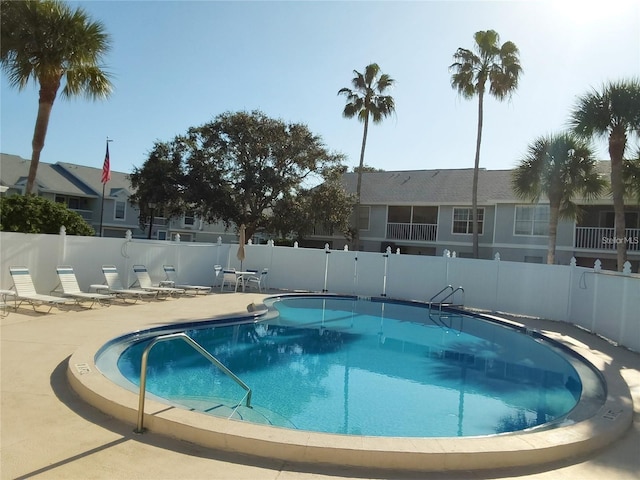 community pool featuring a patio and fence