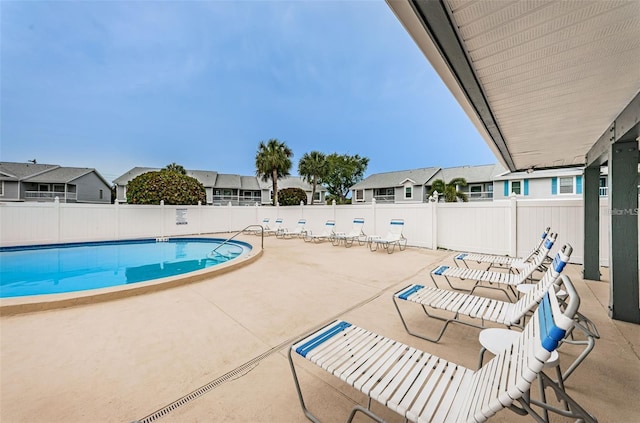 pool featuring a residential view, a patio, and fence