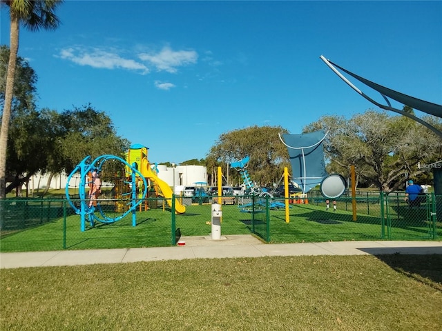 community playground featuring a lawn and fence