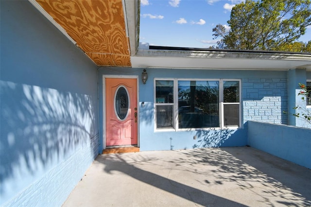 2451 Baywood Dr W, Dunedin, FL 34698 - doorway to property with stucco siding
