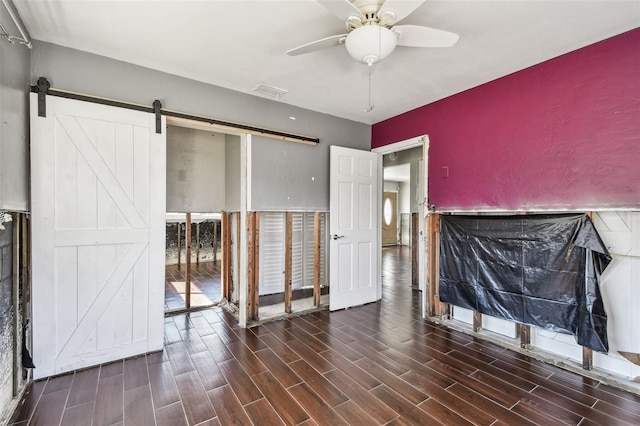 2451 Baywood Dr W, Dunedin, FL 34698 - unfurnished living room with a barn door, a ceiling fan, visible vents, and wood finish floors
