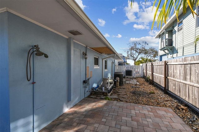 2451 Baywood Dr W, Dunedin, FL 34698 - view of home's exterior with a patio, cooling unit, a fenced backyard, and stucco siding