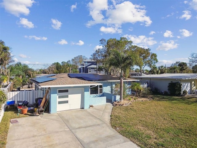 2451 Baywood Dr W, Dunedin, FL 34698 - view of front of home with stucco siding, roof mounted solar panels, concrete driveway, and a front yard